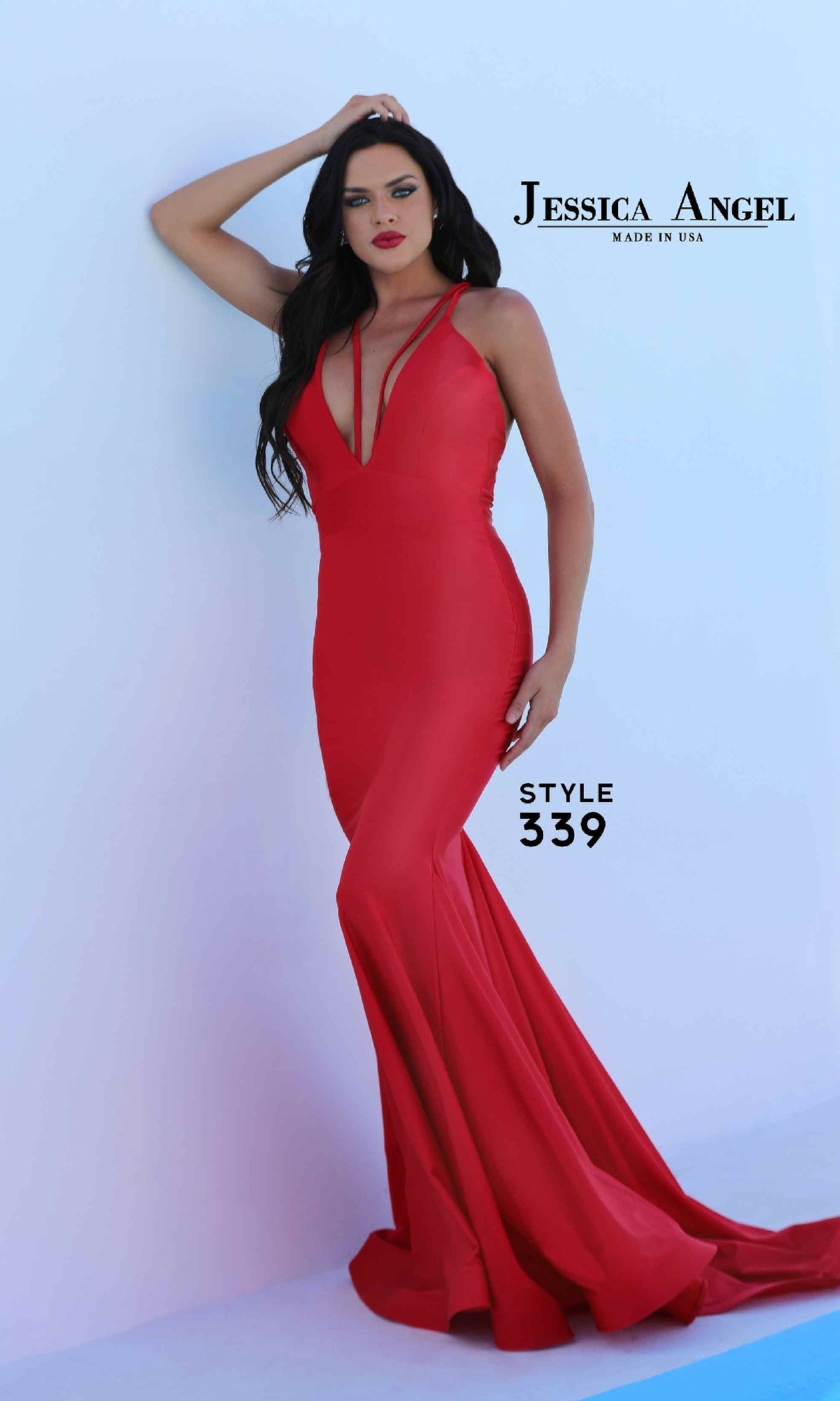 Woman in a fitted red Deep V-Neck Long Prom Dress: Jessica Angel 339 with strappy back and mermaid skirt, posing by a light blue wall. Text reads “Jessica Angel Made in USA” and “Style 339.”.